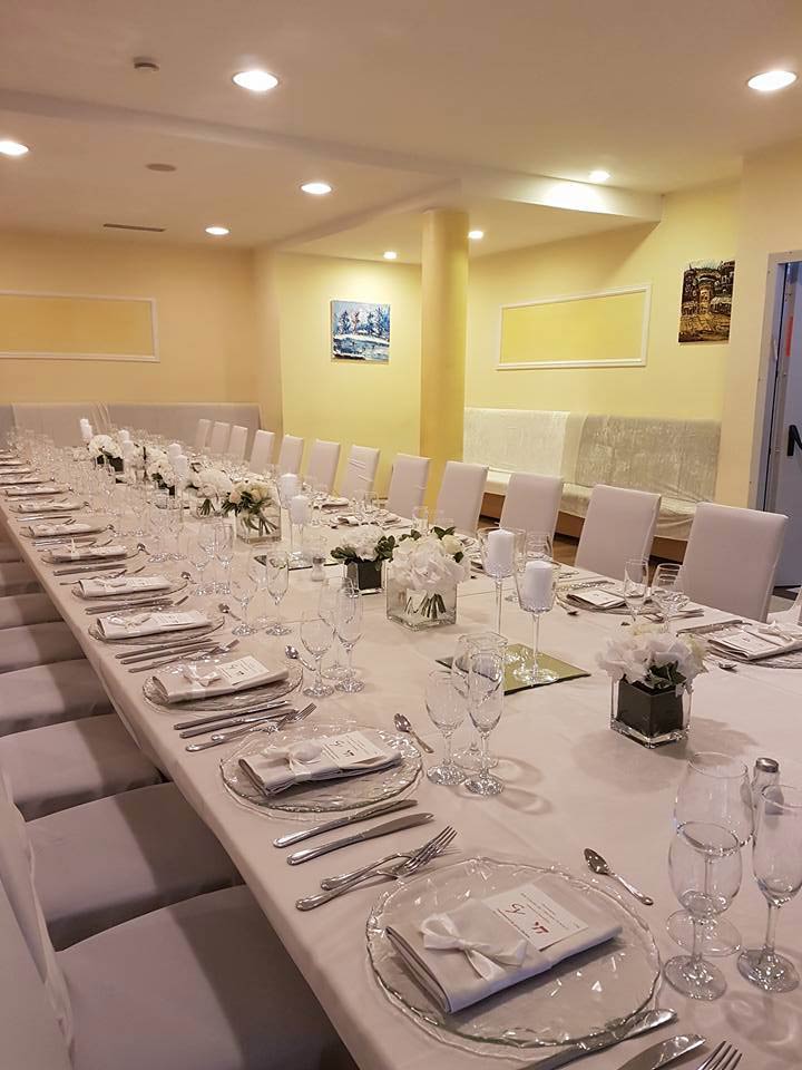 La salle à manger de l’hôtel dressée pour un repas de fête