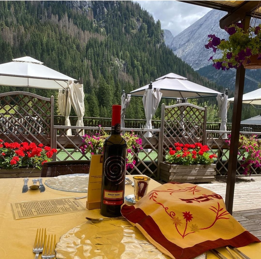 Une table de Chabbat dressée sur la terrasse de l’hôtel, face aux forêts et aux sommets des Dolomites